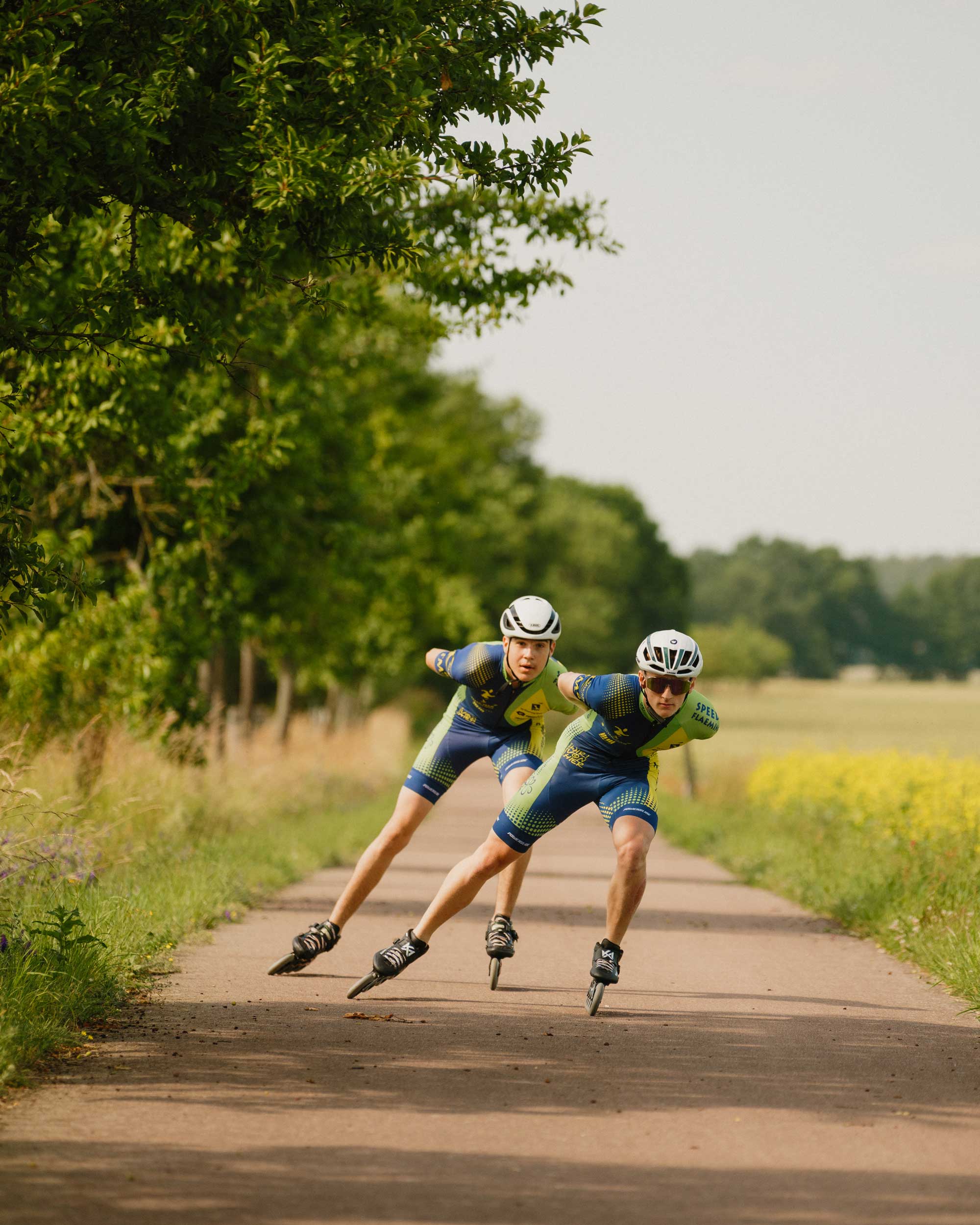 2 Sportskater fahren synchron auf einem Weg in der Natur