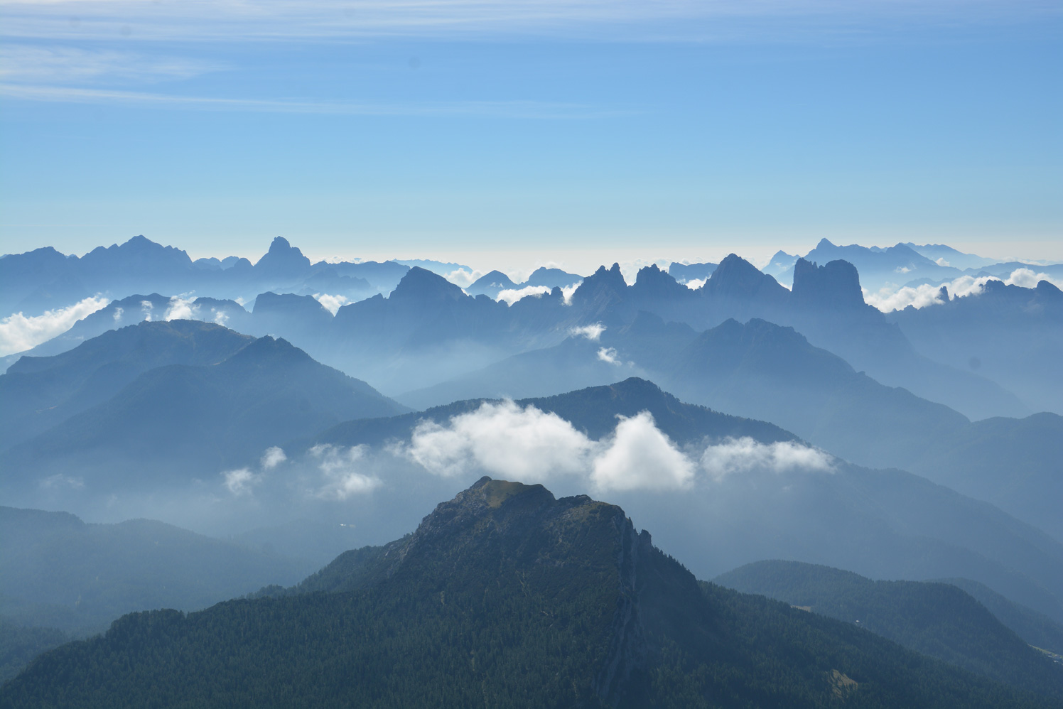 Ausblick über zahlreiche blaue Gipfel bis zum Horizont