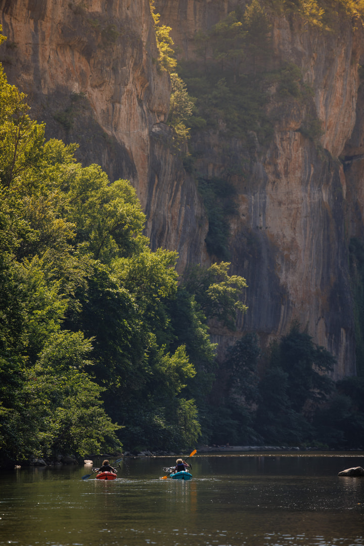 Mächtige Felswände ragen steil direkt neben dem Flussufer auf