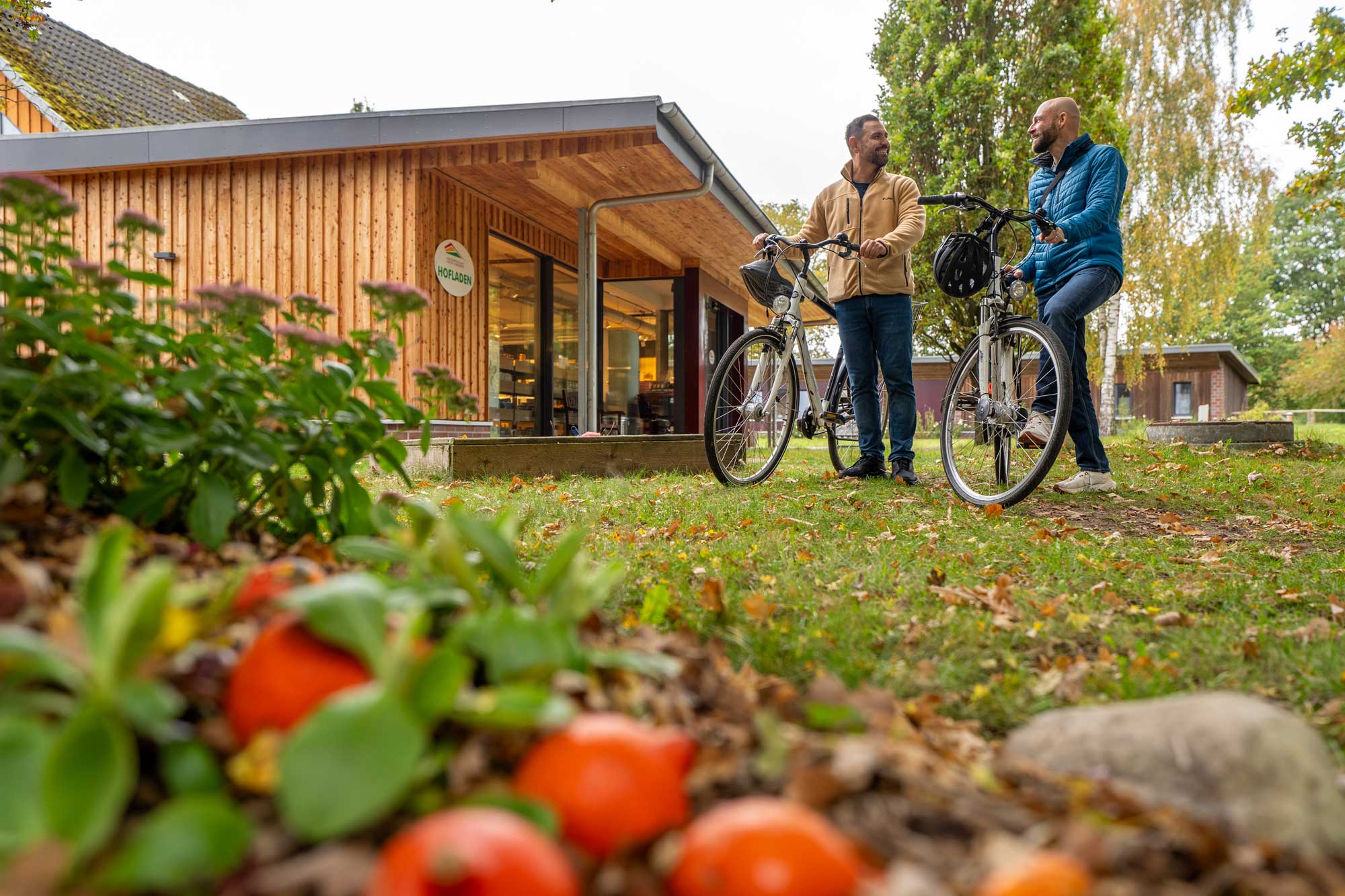 Zwei Radfahrer stehen mit ihren Fahrrädern vor einem Holzhaus