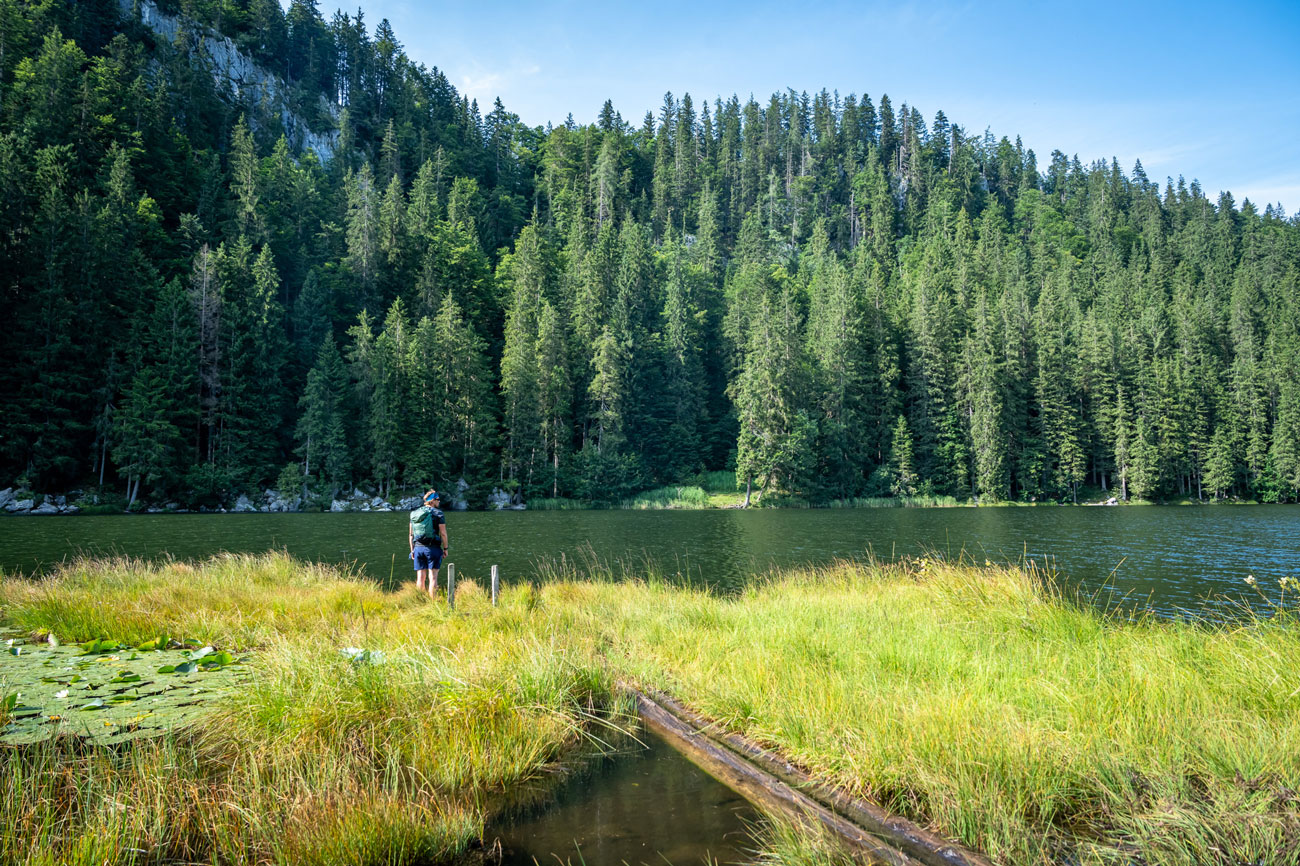 Person am Ufer eines Bergsees