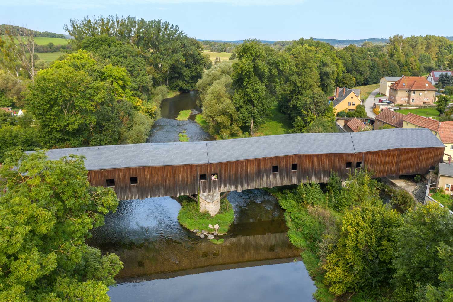 Eine geschlossene Holzbrücke über einem Fluss