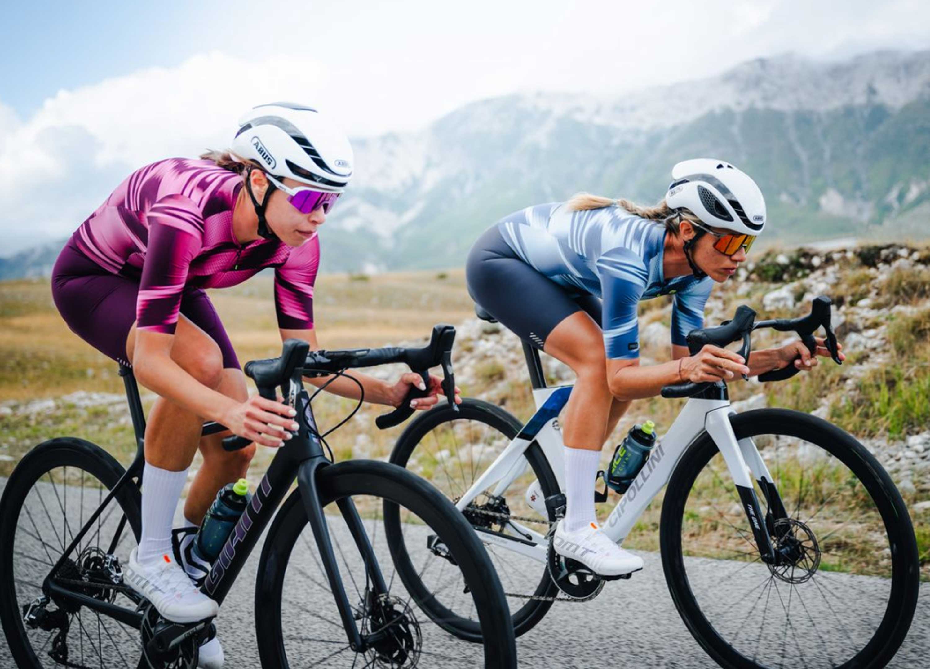 Zwei Frauen fahren auf Rennrädern in den Bergen