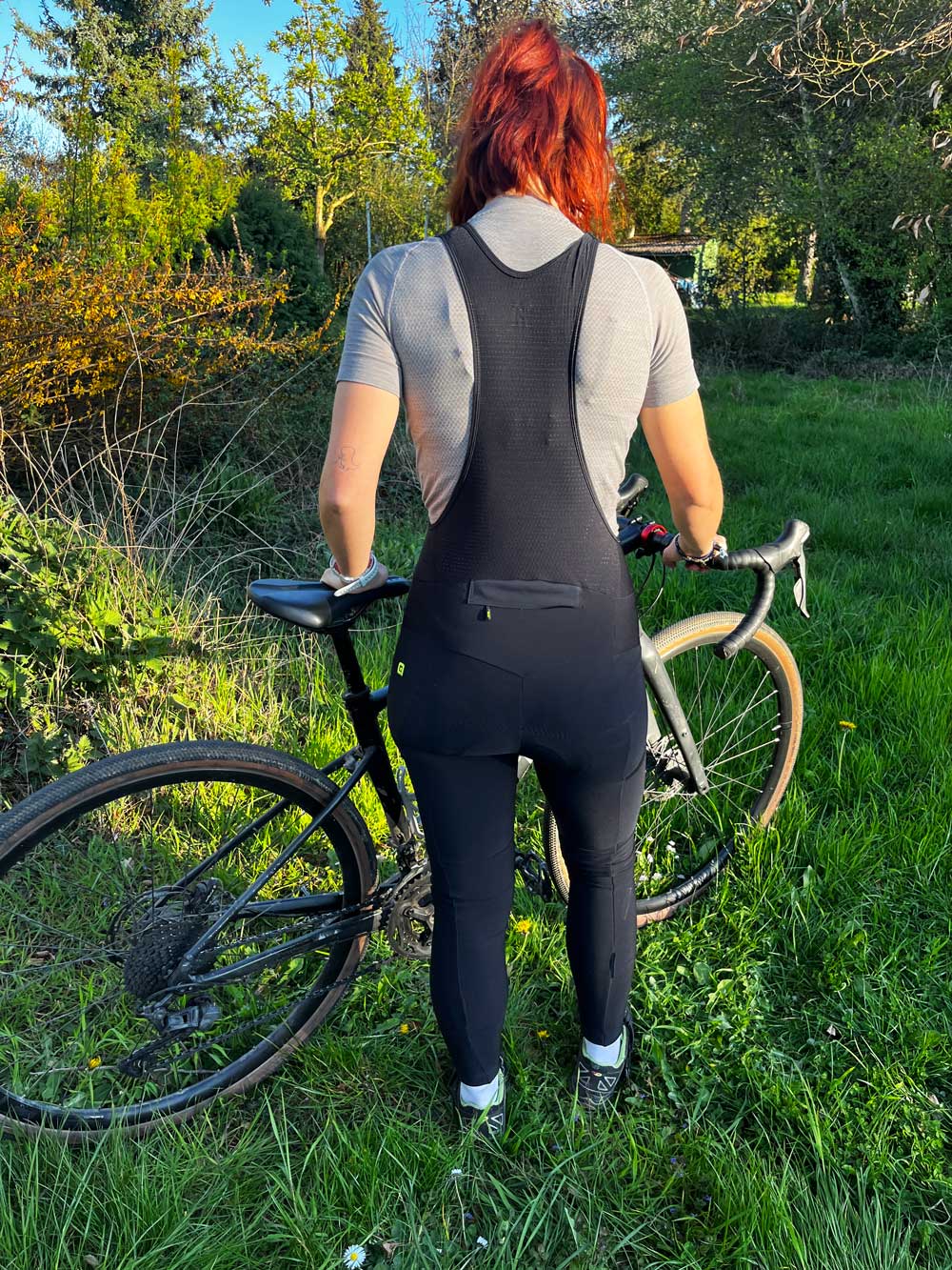 Redakteurin Marieke trägt die Bibtights und steht vor einem Gravelbike
