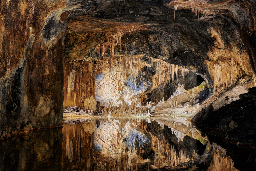 Eine Grotte spiegelt sich in einem kleinen Gewässer. 