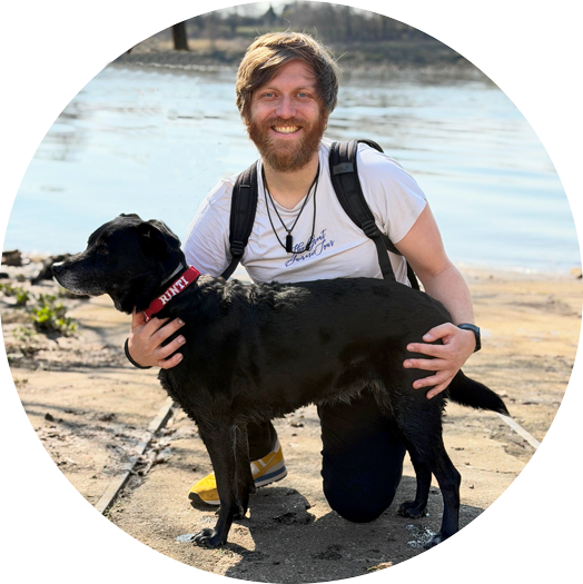 Mann kniet mit schwarzem Hund